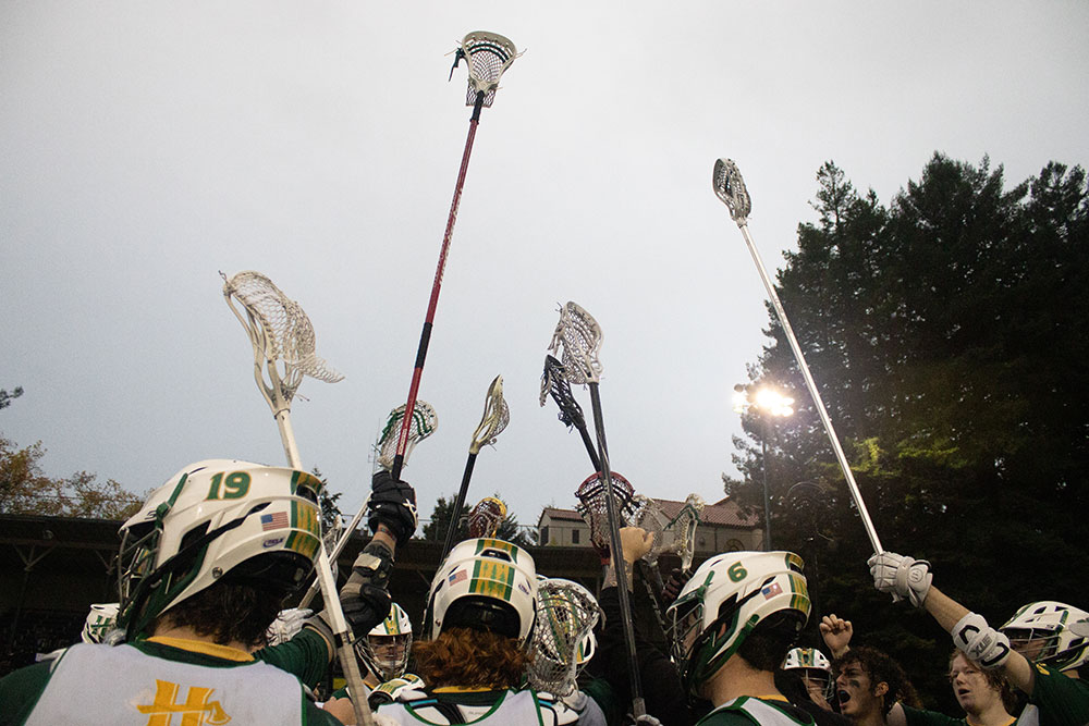 lacrosse players raising their sticks to the sky