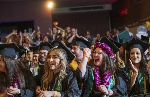 A photo of graduates at the College of Professionals Studies Commencement Ceremony hosted at the Eureka Theater. 
