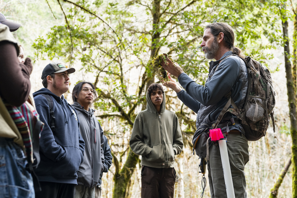 professor showing students a plant at a watershed