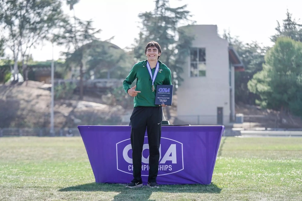 Pole vaulter Michael Payan stands proudly with "Field Athlete of the Meet" plaque. 