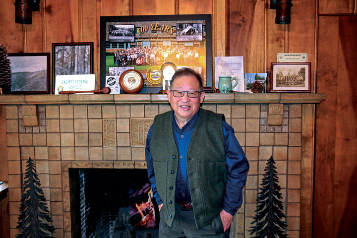 Cal standing in front of a fire with his awards