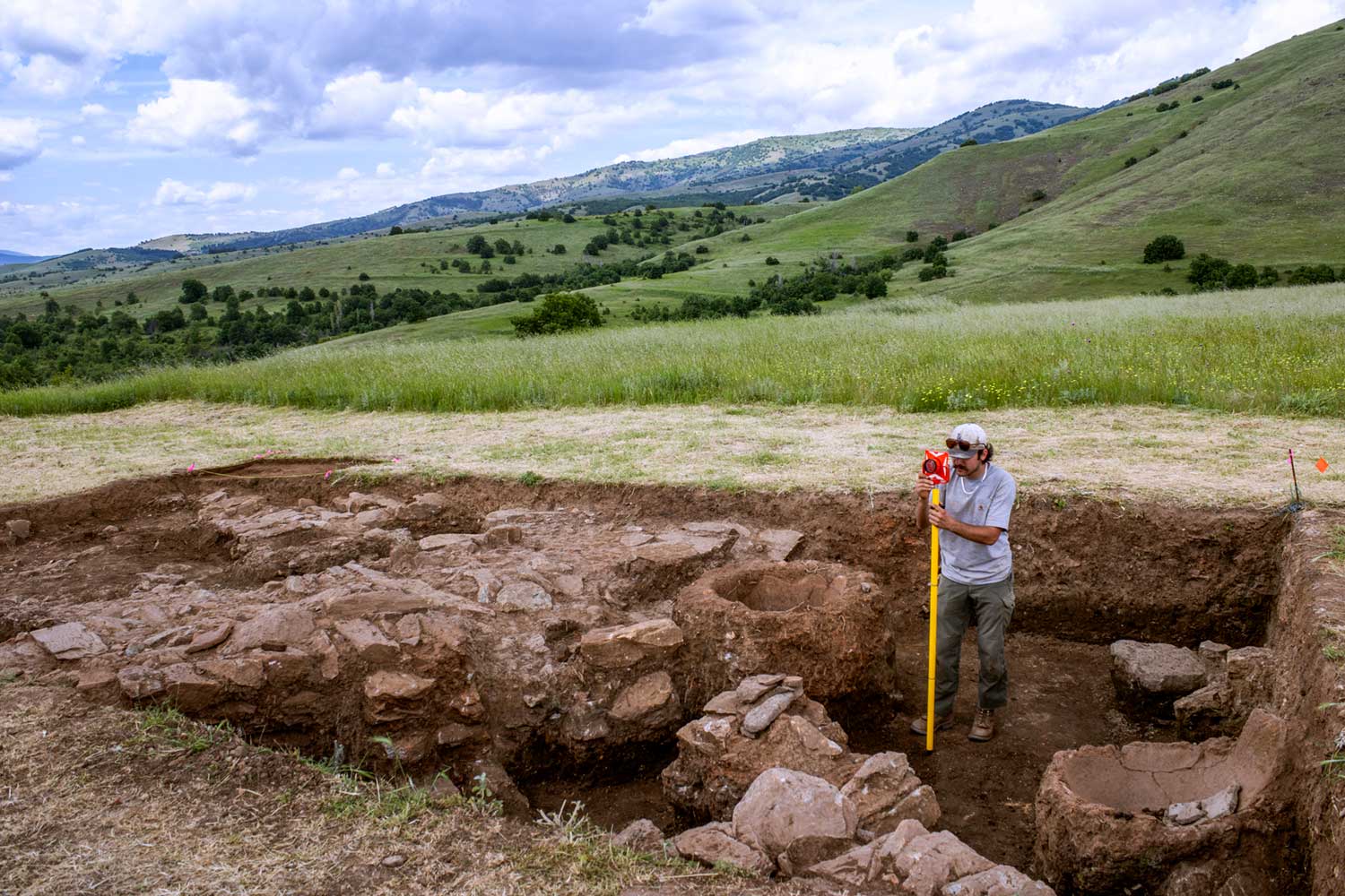 A man stands in a hole in the ground, looking around with a focused expression