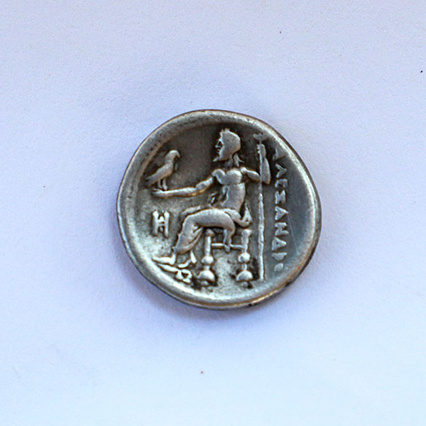 Ancient Greek coin featuring a woman seated on a throne, showcasing intricate details and a polished finish