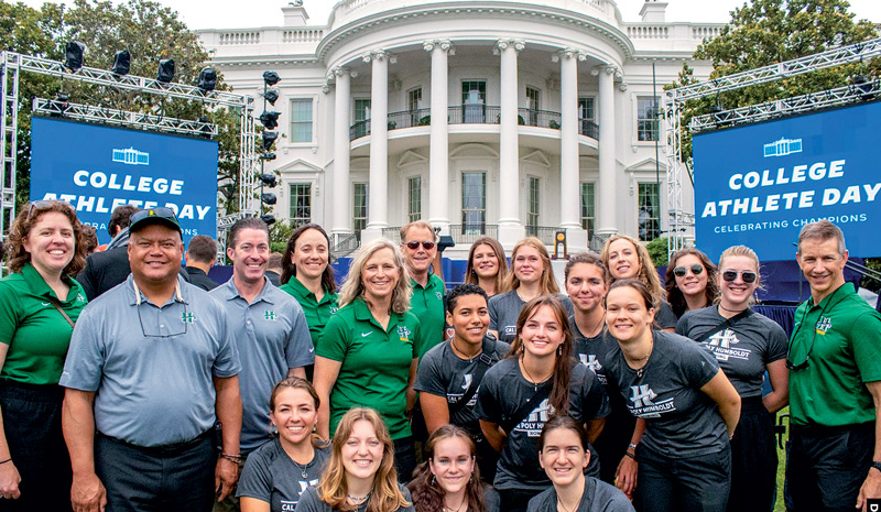 The rowing team in front of the white house with the president of the University