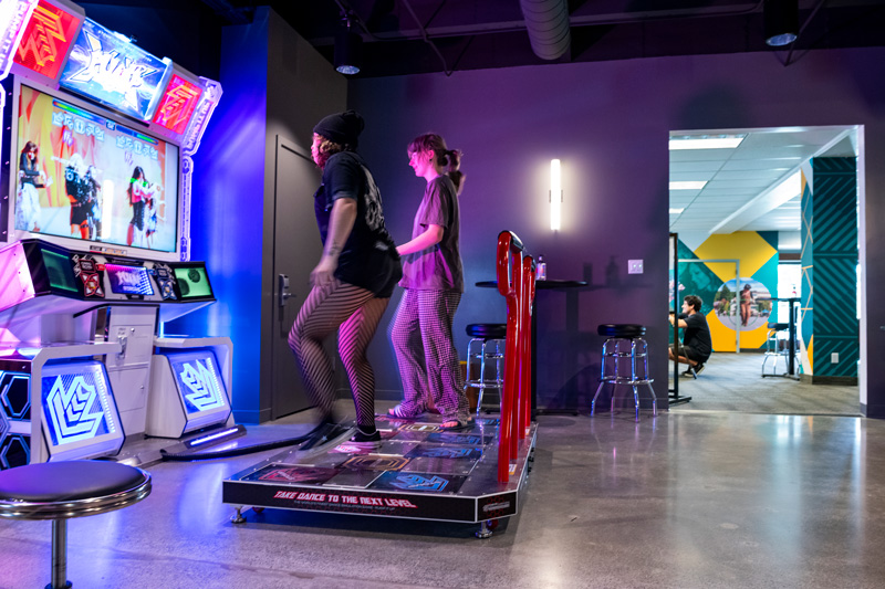 Two people engaged in playing video games together in a recreation room setting