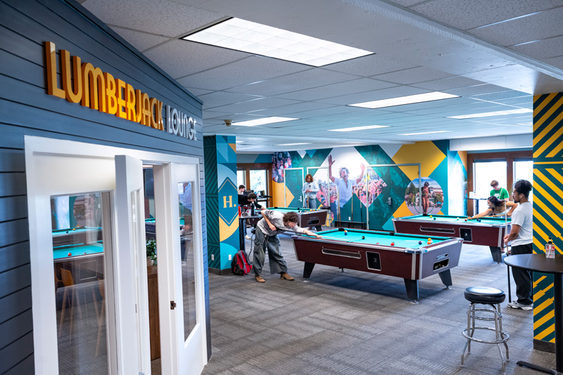 A lively room featuring several pool tables and people playing pool, inviting for social gatherings and games
