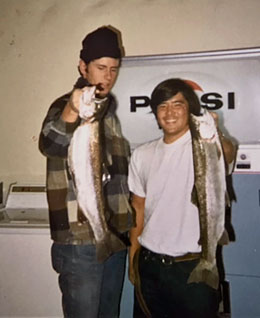 Craig Tucker (left) and Randy Ishihara (right) showing off their steelhead trout after a day of fishing on the Trinity River. Afterward, the crew would head to the basement of Maple Hall, where in a small kitchen and laundry area, they'd clean and then cook the catch of the day..