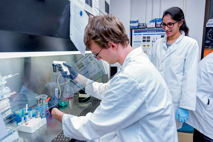 students in white coats in the lab