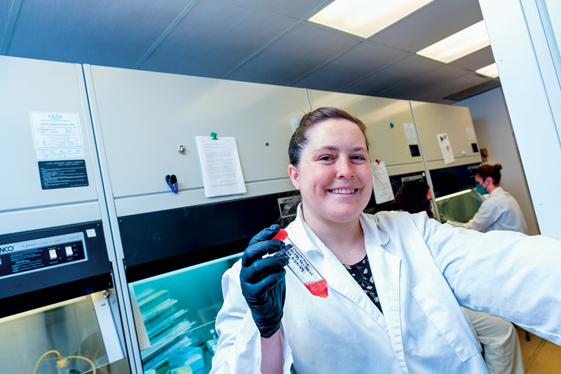 A student in the lab holding up a specimen