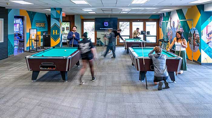 A group of people enjoying a game of pool in a lively indoor game room
