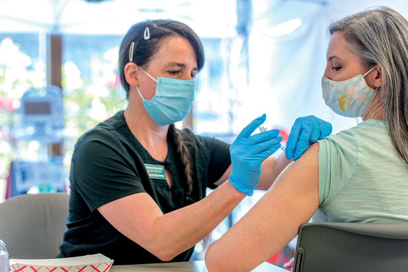 a staff member getting a vaccination shot in the arm