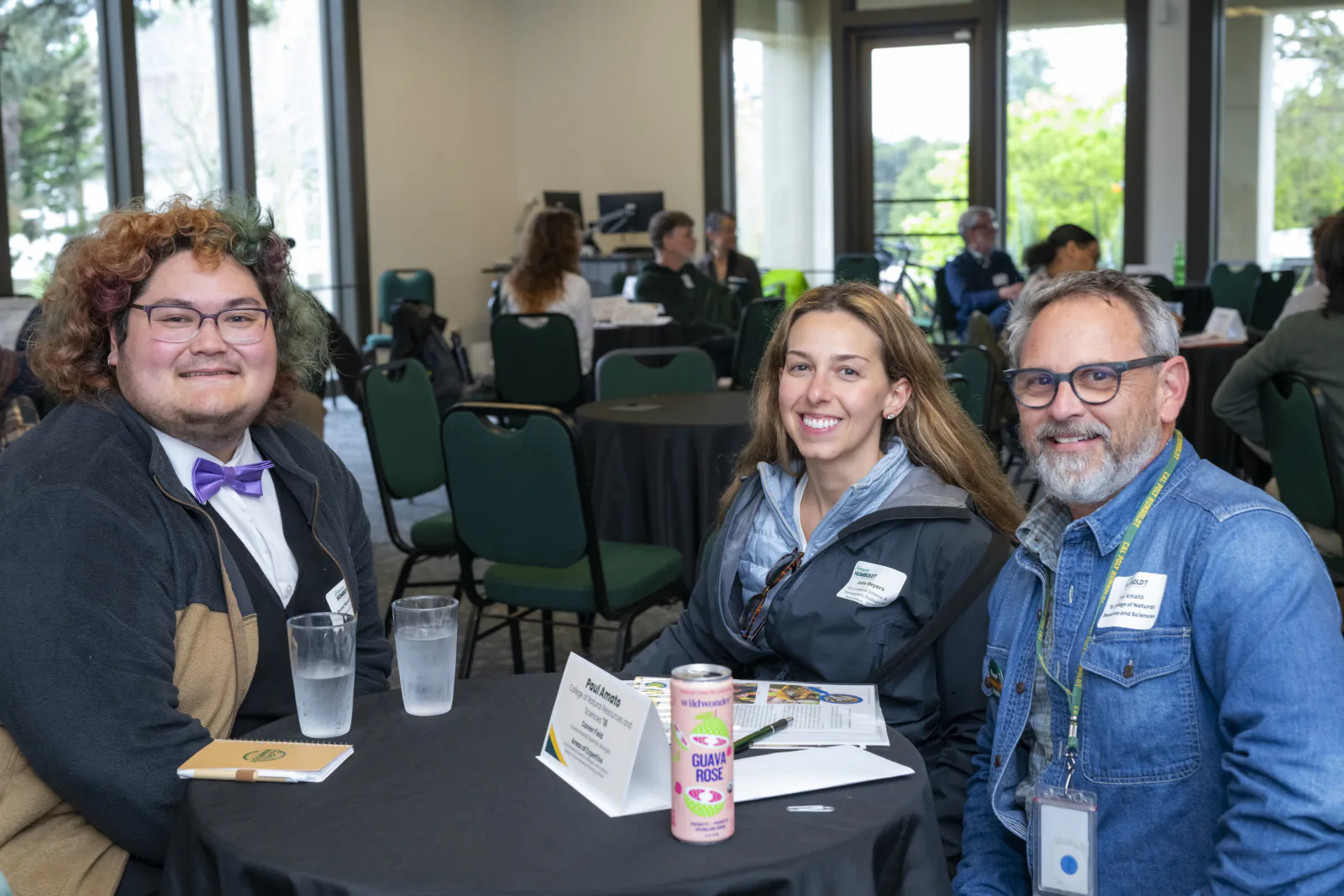 Jared Kawanami, Julie Meyers, and Paul Amato sit together at an Alumni Connections table.