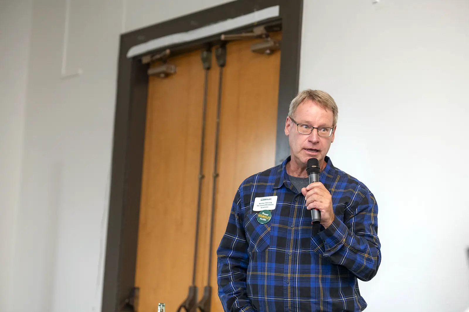 Walter Herzog speaks into a microphone during the Alumni Connections event.