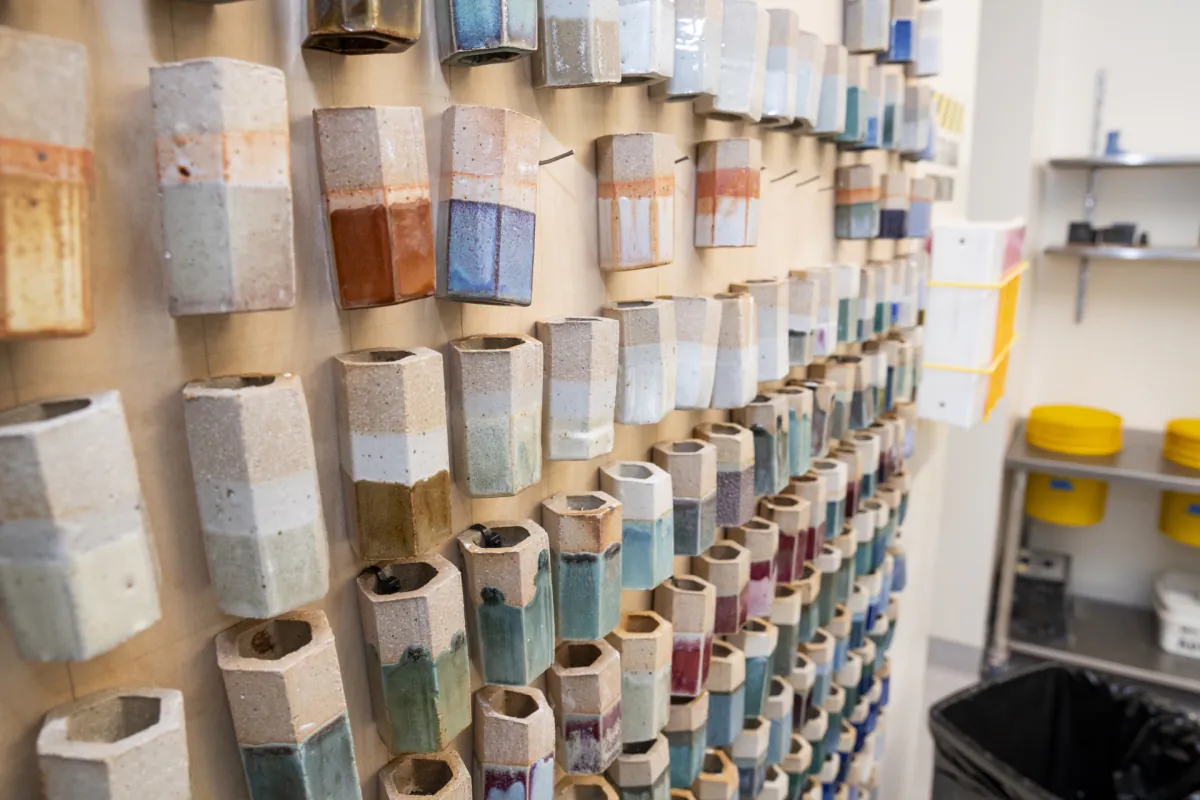 Glaze test tiles arranged on the wall of the glaze room