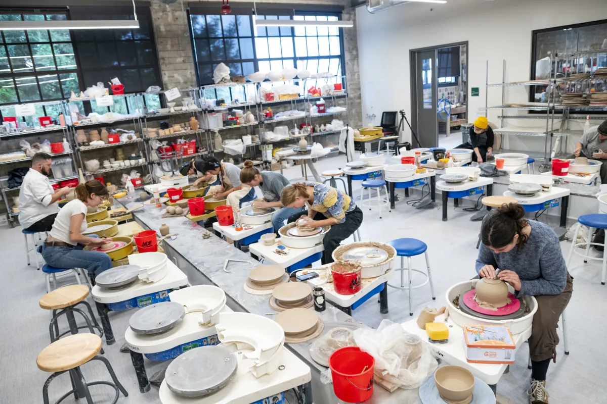 Students working at pottery wheels in the renovated Ceramics Studio