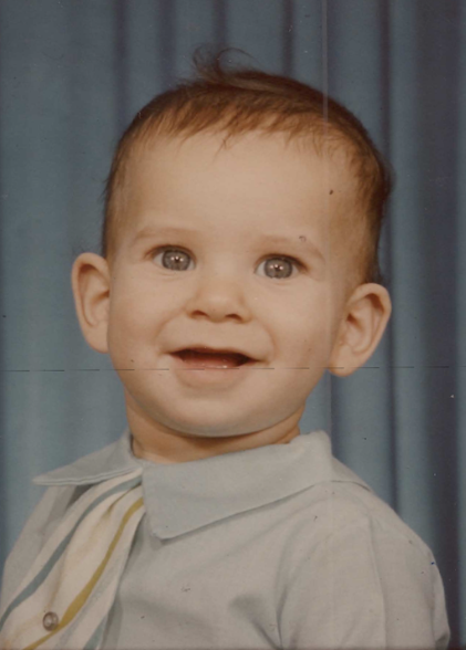 Young Richard Carvajal smiles at the camera as a baby.