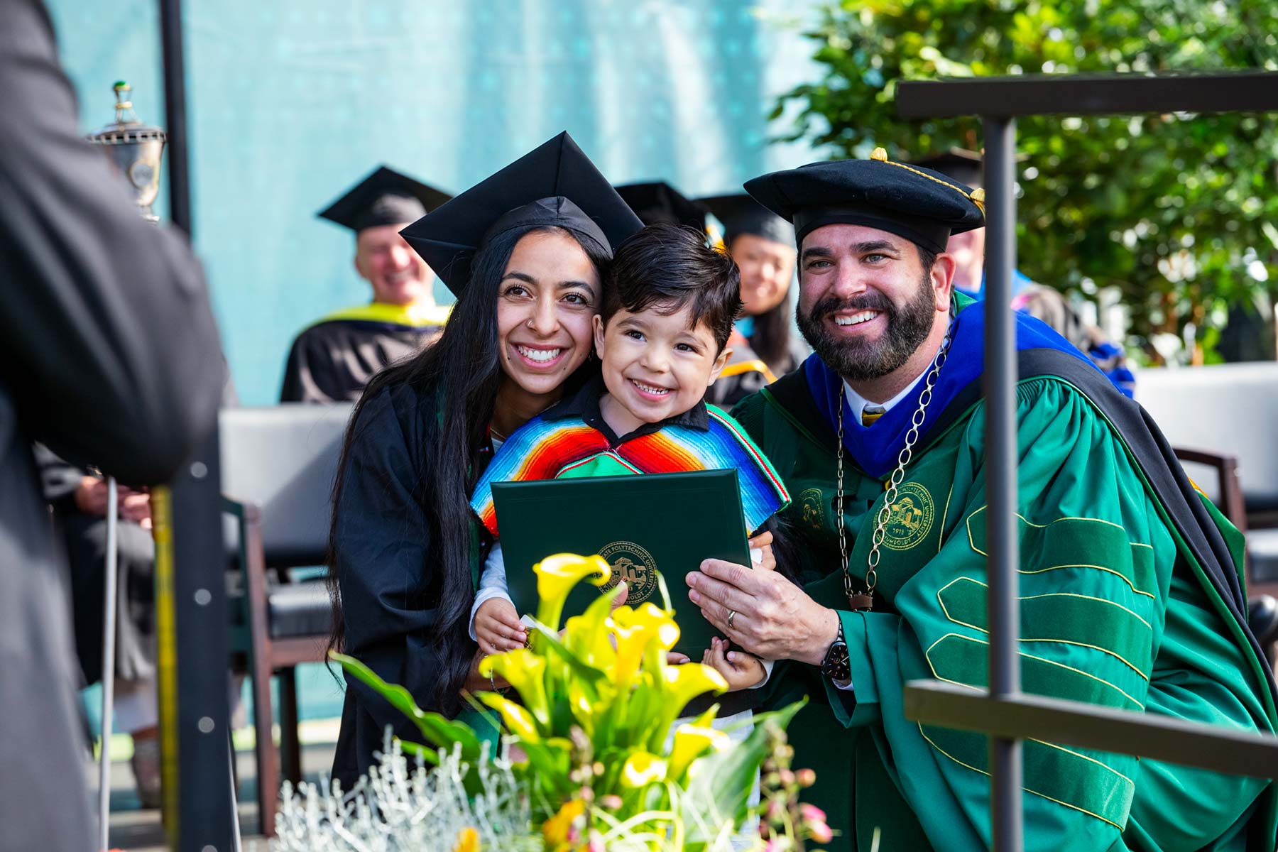 Richard Carvajal poses with graduate and child.