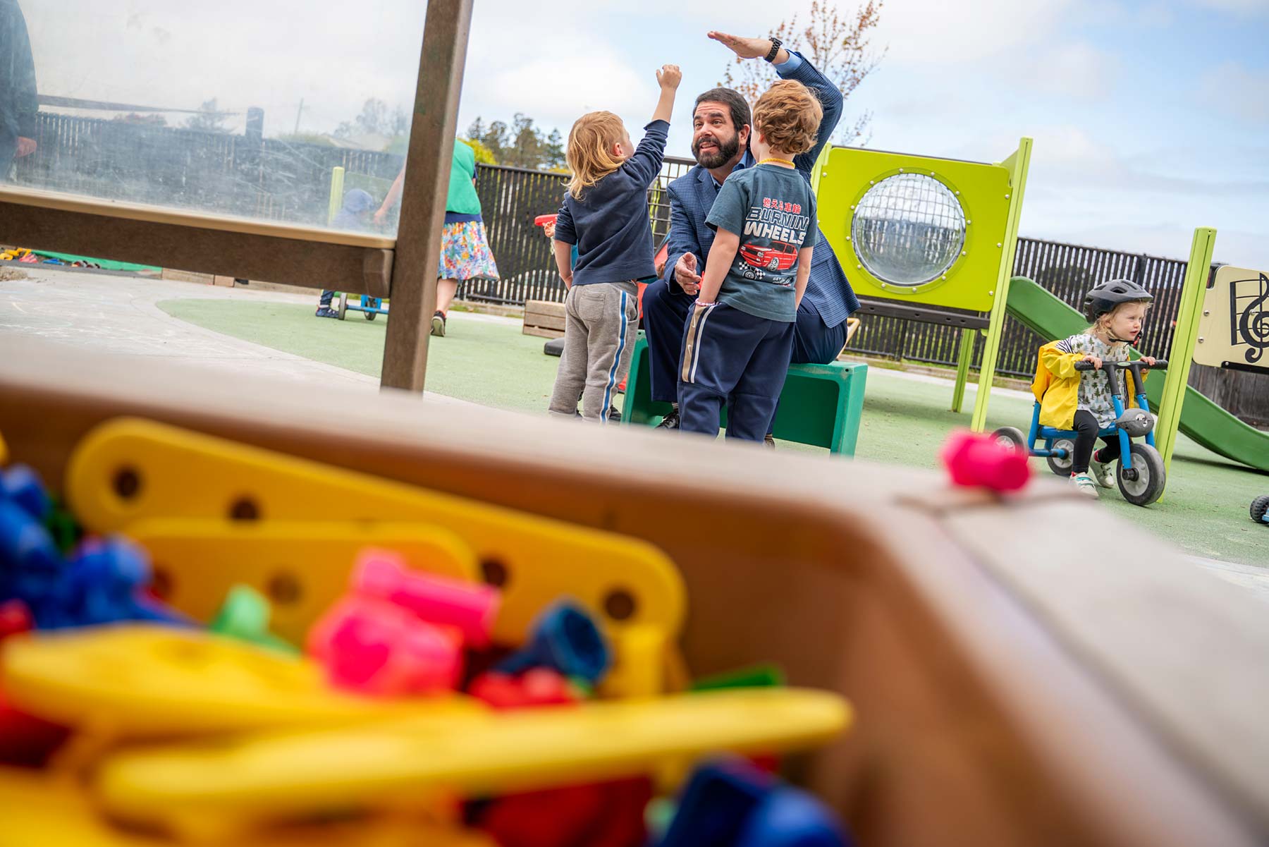 Richard Carvajal talks with children on a playground.
