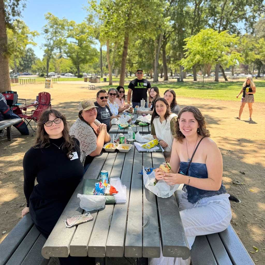 Families and future students at a Student Send-Off event sitting at a picnic table