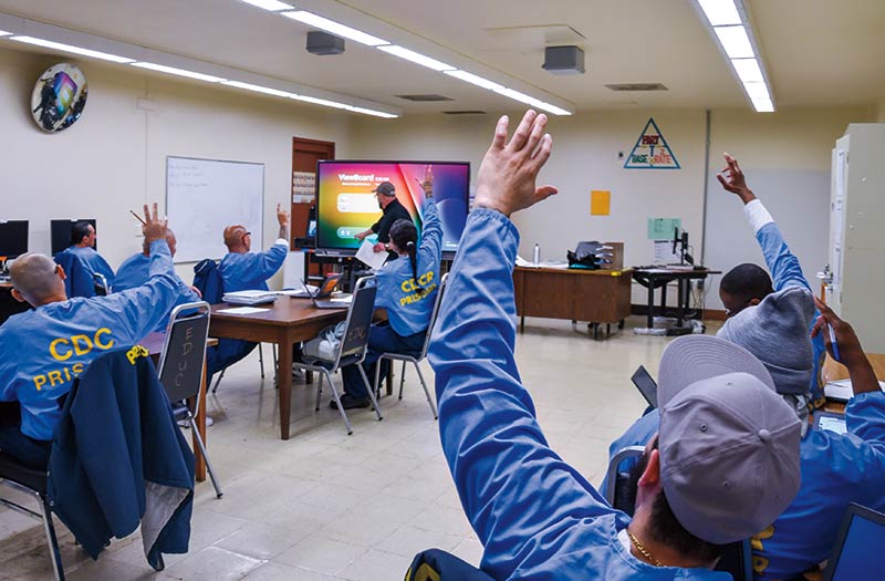 pelican bay students in a classroom raising their hands