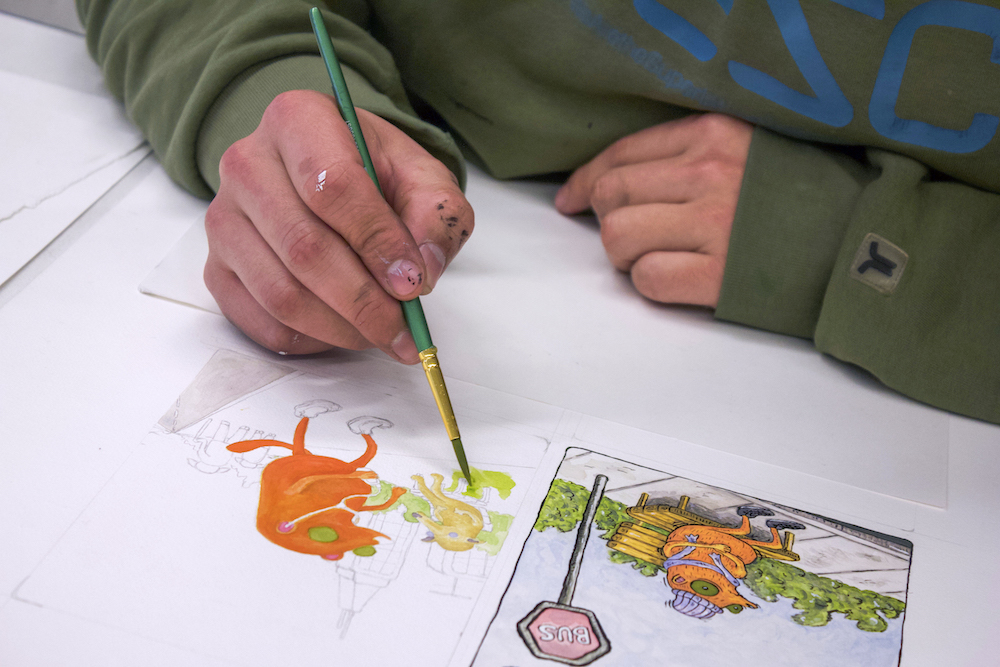 someone painting an illustration with an animnated version directly next to it. 