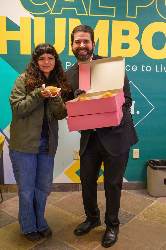 A photo of Cal Poly Humboldt President Richard Carvajal handing out donuts to students across campus on the first day of spring semester.