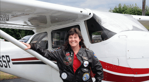 Meg Godlewski standing in front of a small plane.