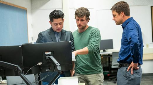 Associate Professor Josh Zender ( right) and students Francky Mirafuentes ( left), and Daniel Taylor (center) at the on-campus VITA tax clinic on Wednesday, Feb. 8.