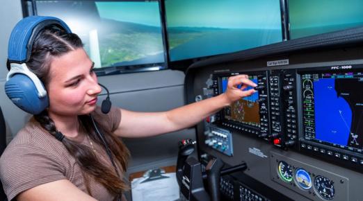 A photo of a student in the Library's newest flight simulator. 