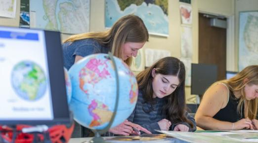 A photo of Geography Lecturer Jessica Janecek helping a student in class. 