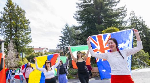 Members of the campus community carrying flags from different nations as part of the IEW's flag parade. 