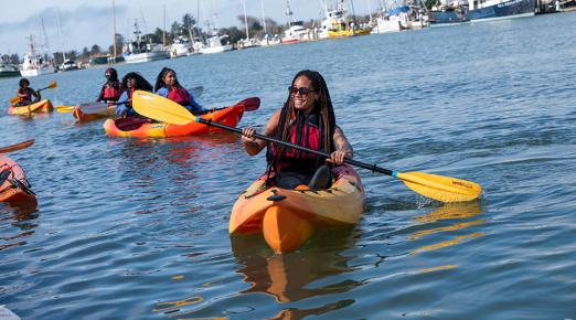 student in kayak paddling in Humboldt Bay as part of a Black to the Land event 