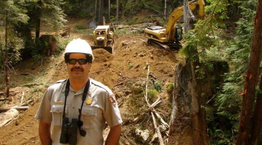 A photo of Leonel Arguello in front of active restoration efforts in Larry Dam Creek circa 2006. 