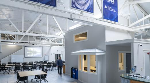 photo of the inside of the new center with chairs and tables and banners with partners' names on it