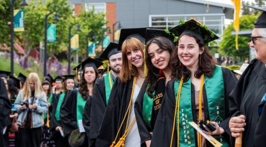 A photo of three graduates smiling at the camera during Spring Commencement 2025.
