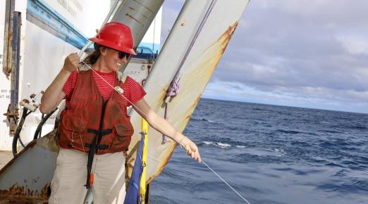 Claire Till holding a line off the side of a ship