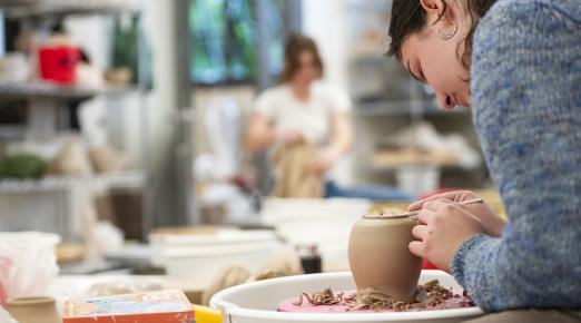 student sculpting clay