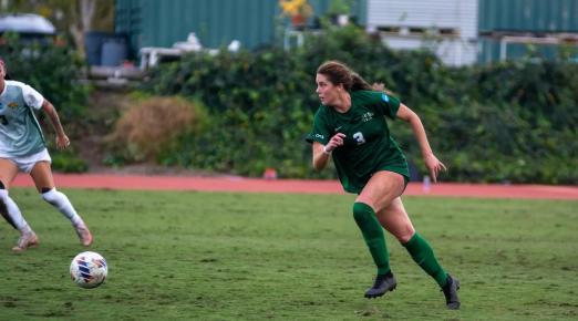 Women's Soccer player on the field running toward ball