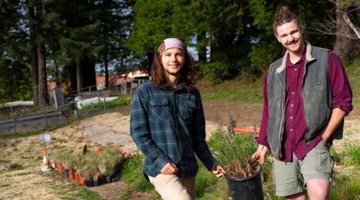 A photo of students Jack McCann and Carter Daniel holding a native plant ready to be planted in the pocket prairie sight. 