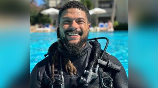 A photo of Kory Lamberts in a pool wearing scuba diving gear. 
