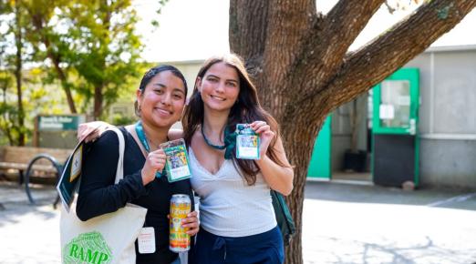 A photo of two students posing for a photo while holding up their Spring Preview name tags. 