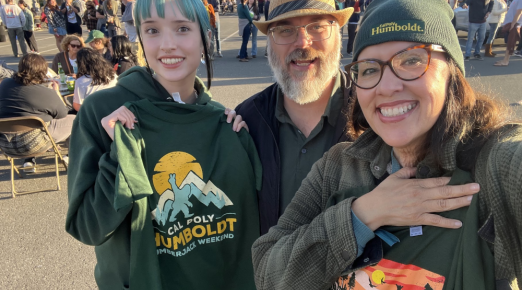 A photo of Cal Poly Humboldt Geology student Angelina Regan with her parents at Lumberjack Weekend