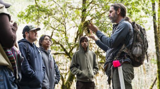 professor showing students a plant at a watershed