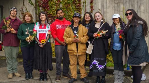 A group of students and staff standing side by side and smiling at the camera. 