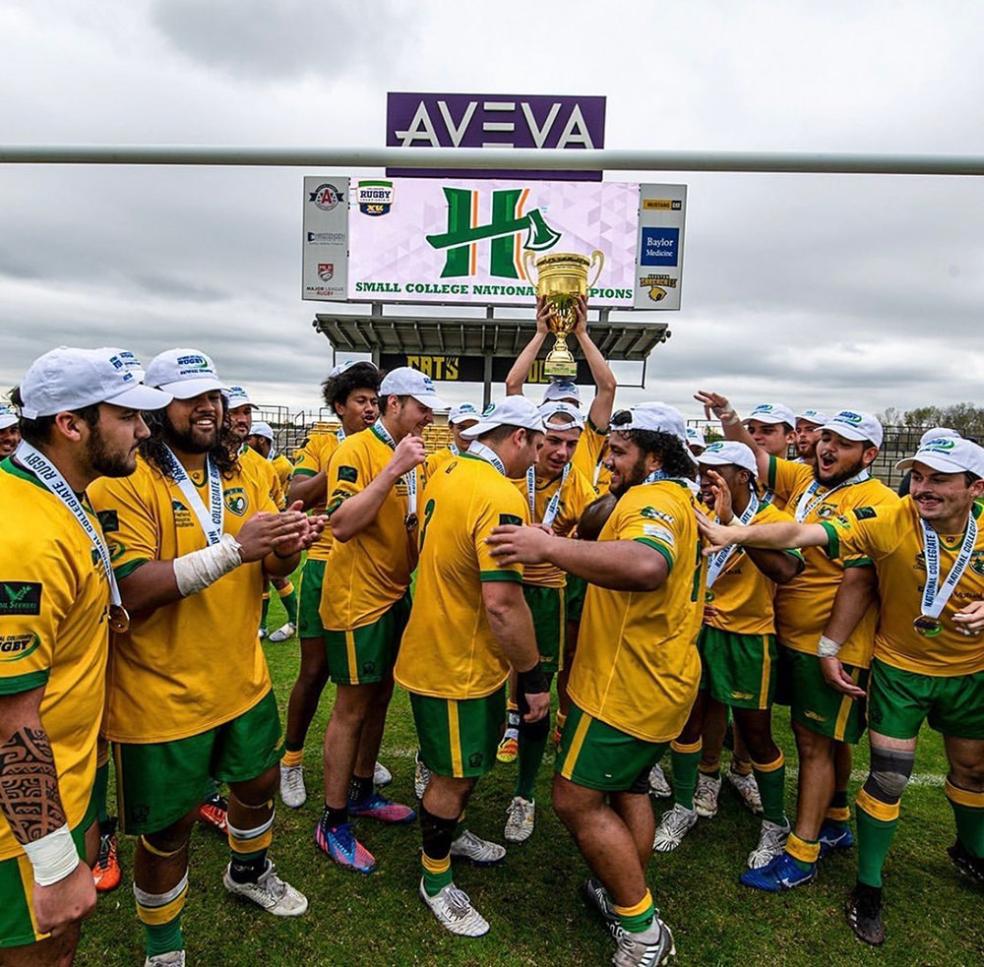 Rugby plays hoist the trophy after winning the national championship.
