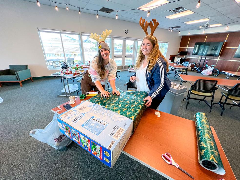 Volunteers wrap gifts for local children. 