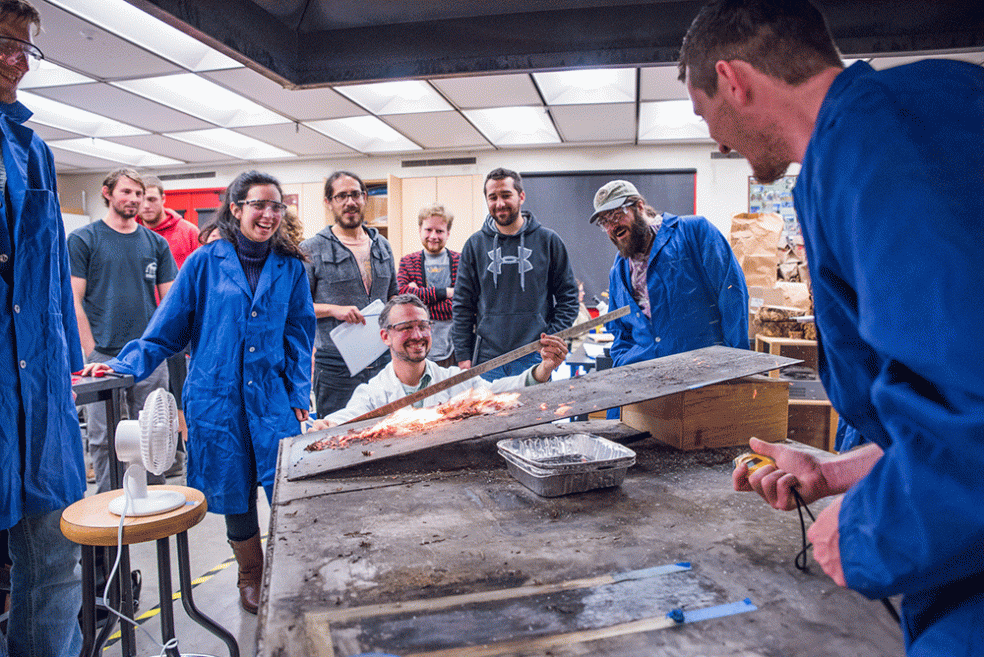 Students and a professor study burning material in the Cal Poly Humboldt Fire Lab