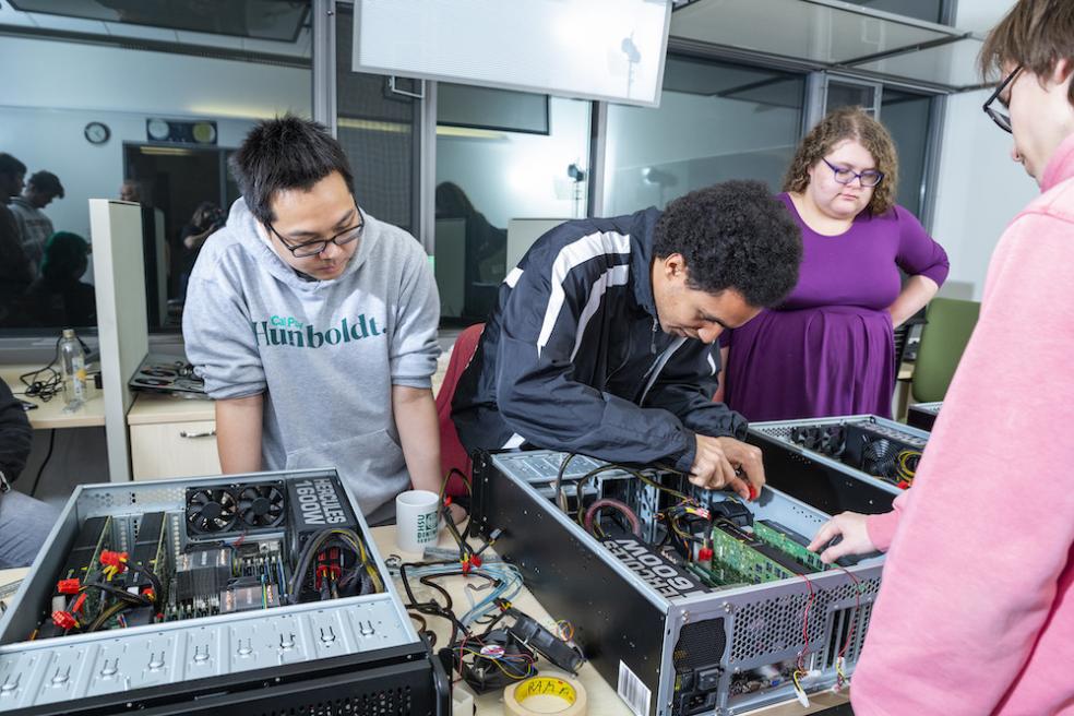 students gathered around a supercomputer 