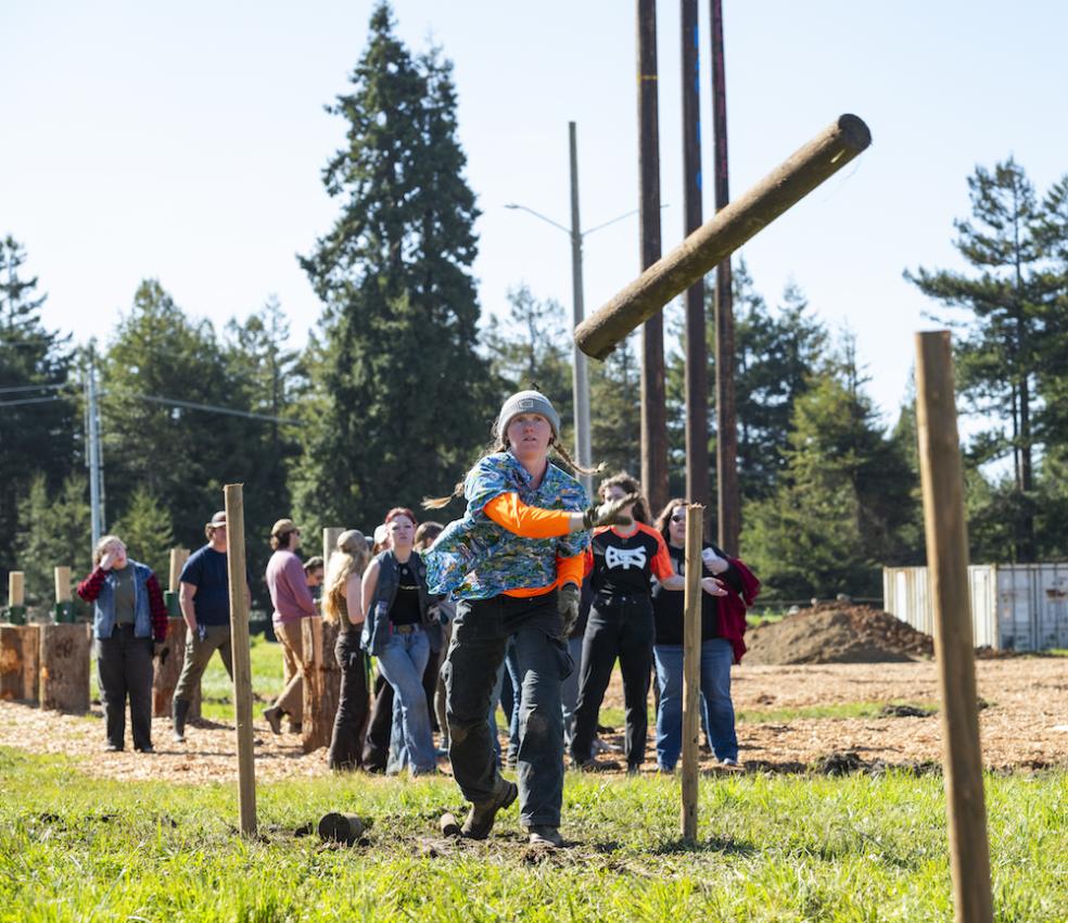 Cal Poly Humboldt student Zoey Cardoza competes in the caber toss competition.