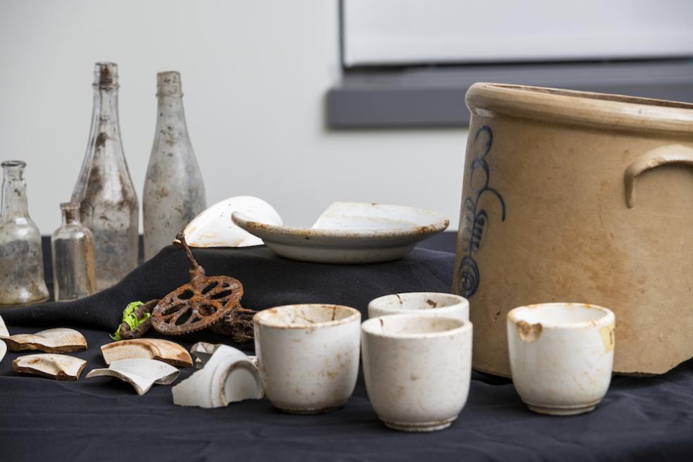 Items including cups, plates, a pickling pot, and condiment bottles that were found during excavations of one of the town’s cookhouses.
